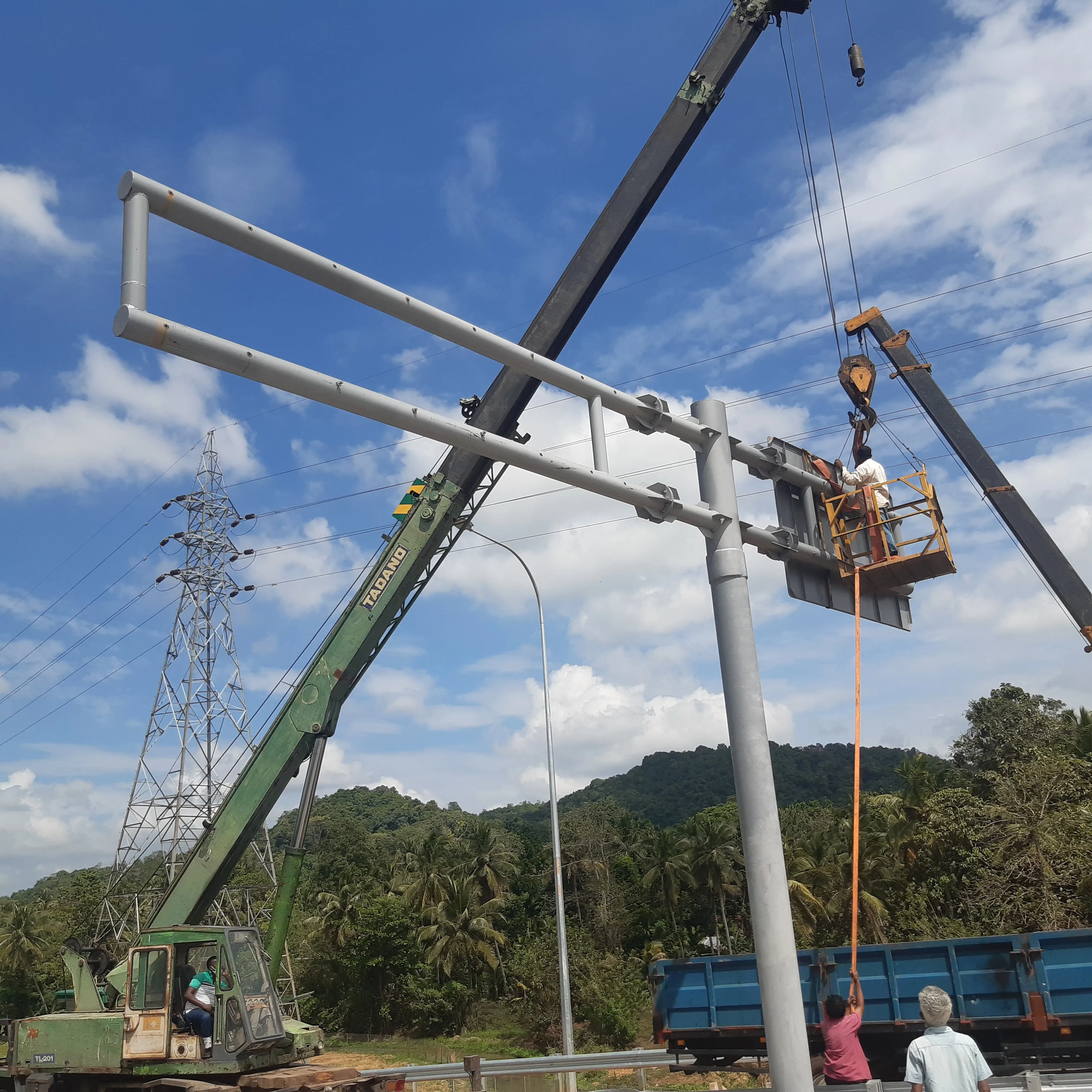 Overhead gantry sign structure being erected by crane on expressway