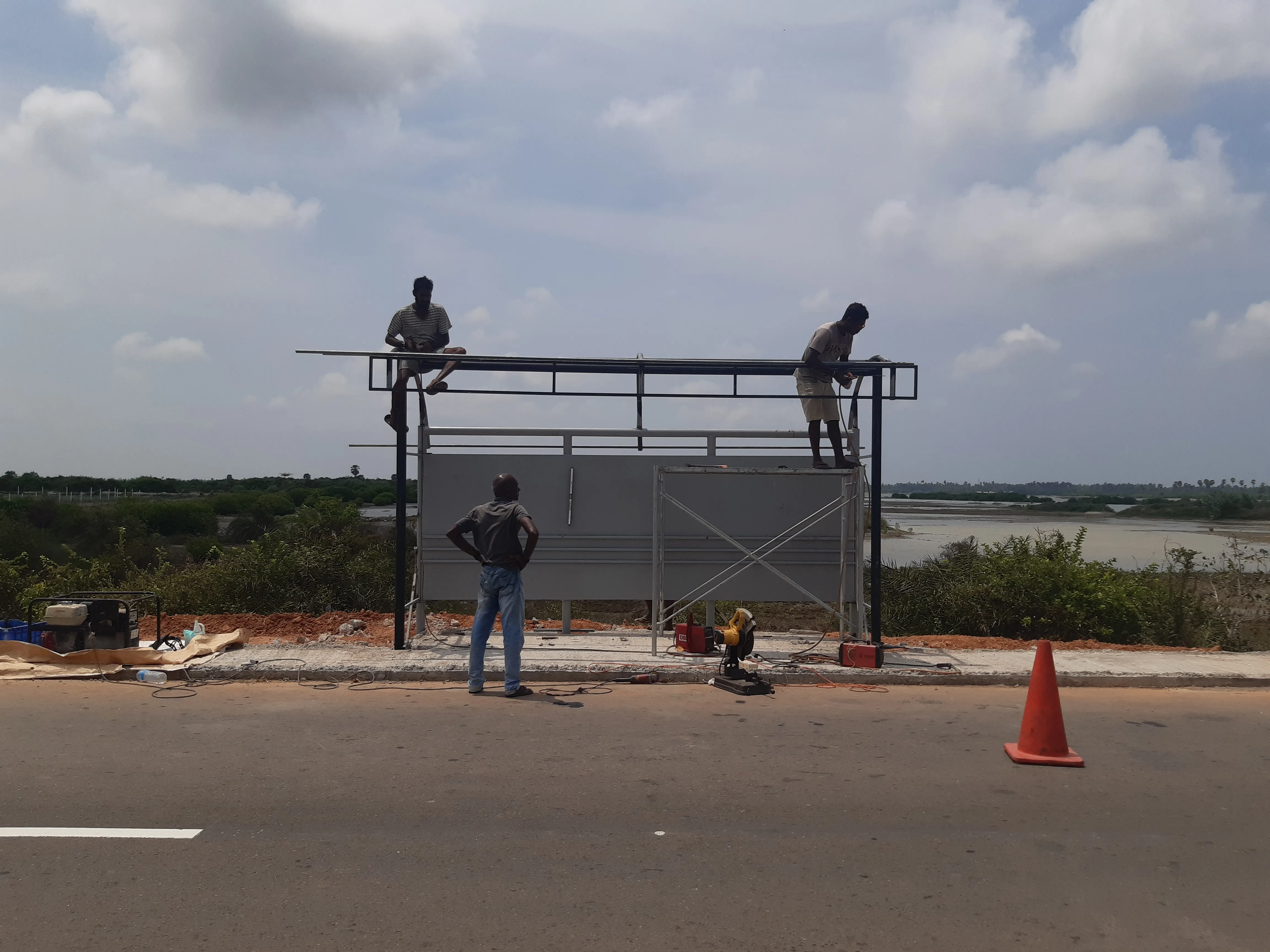 Bus stop steel structure under construction with workers on site